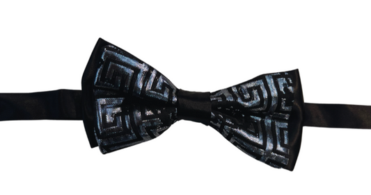 A bow tie with a geometric pattern, featuring a mix of silver and black colors on a dark background.